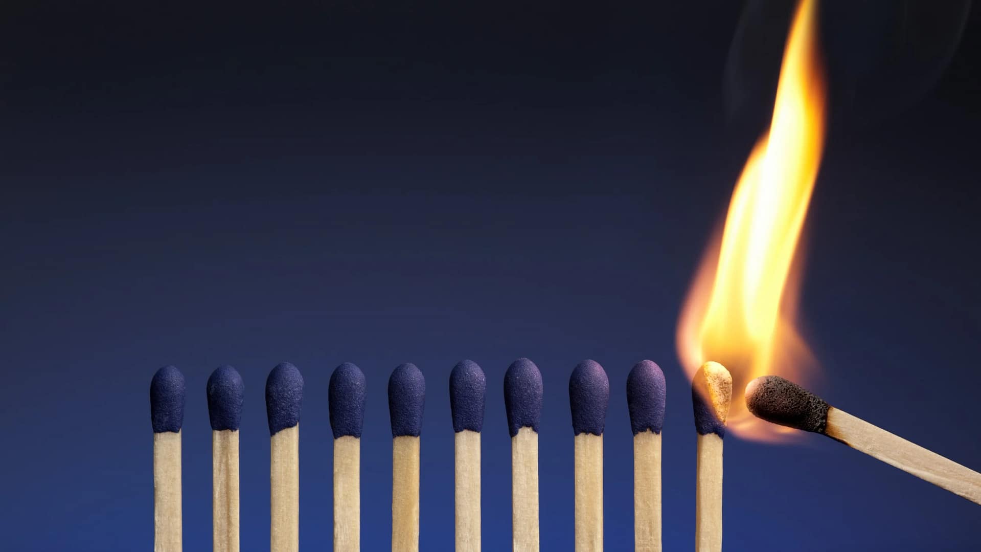 One lit match lighting a row of matches, representing a leader's influence spreading