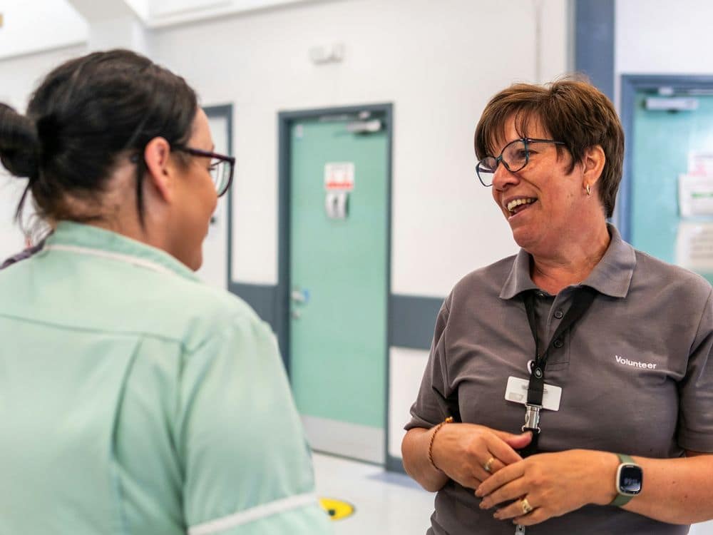 Two health care staff laughing together at work, joy at work in health care