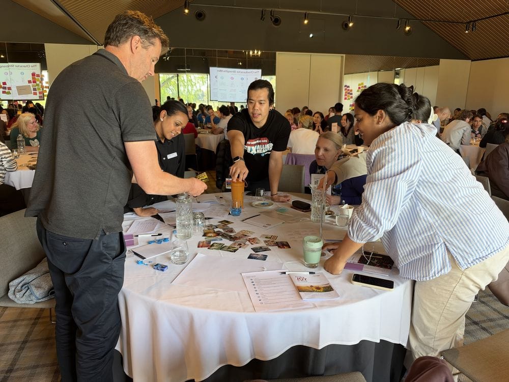 Team choosing photo cards to share best-self stories during the Character Strengths Mirror activity